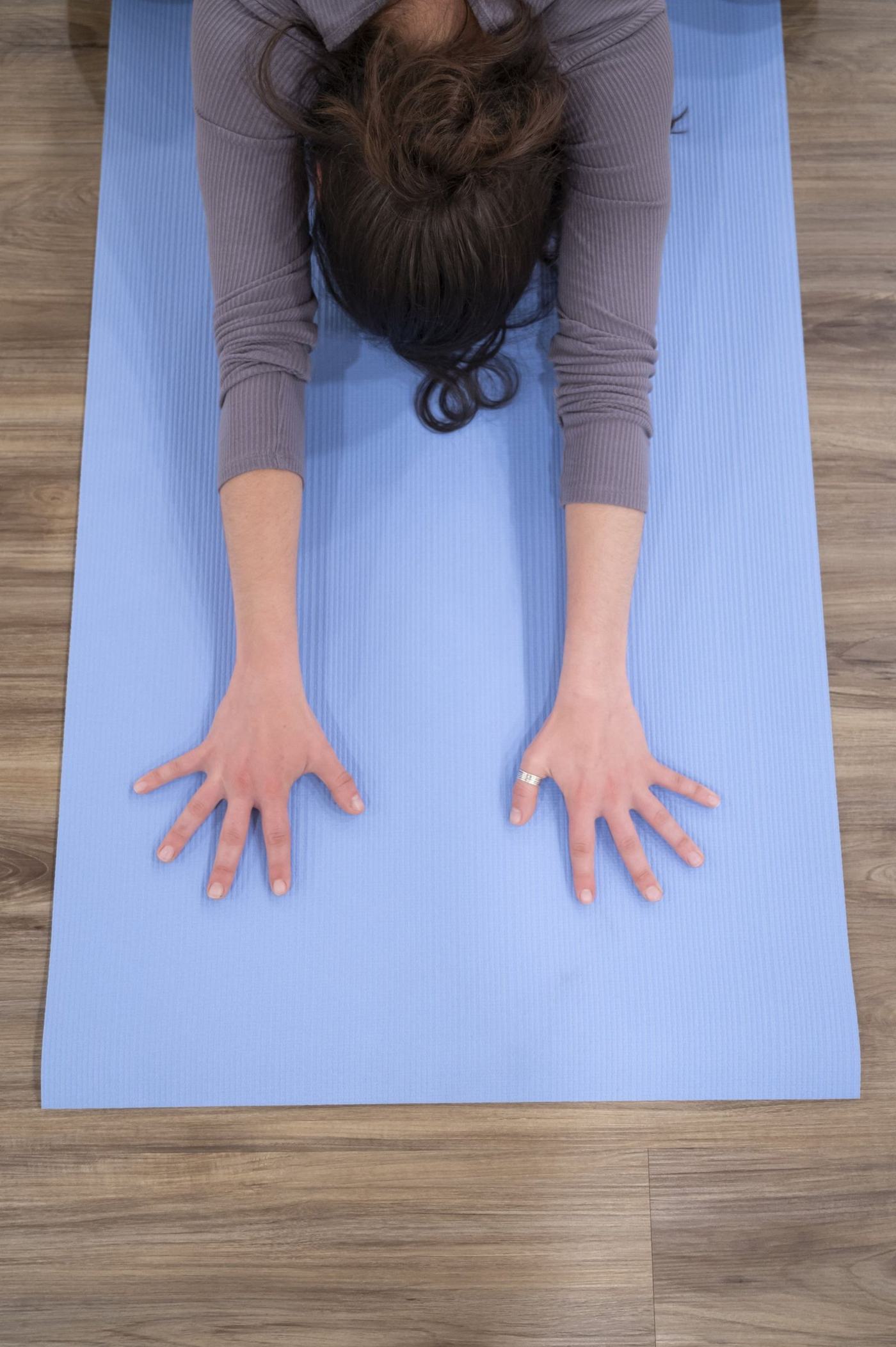 A calm child's pose stretch on a yoga mat at Lotus Hot Yoga